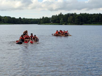 Zwei Gruppen mit Floß auf See