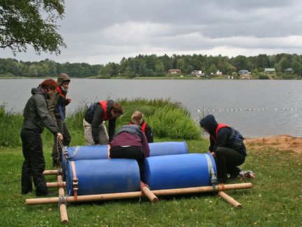 Gruppe mit Floß am Ufer